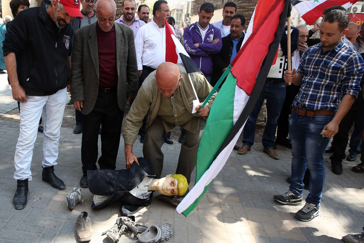 Manifestantes palestinos colocam calçados sobre a cabeça de um boneco que representa o presidente dos EUA, Donald Trump | JAAFAR ASHTIYEH/AFP