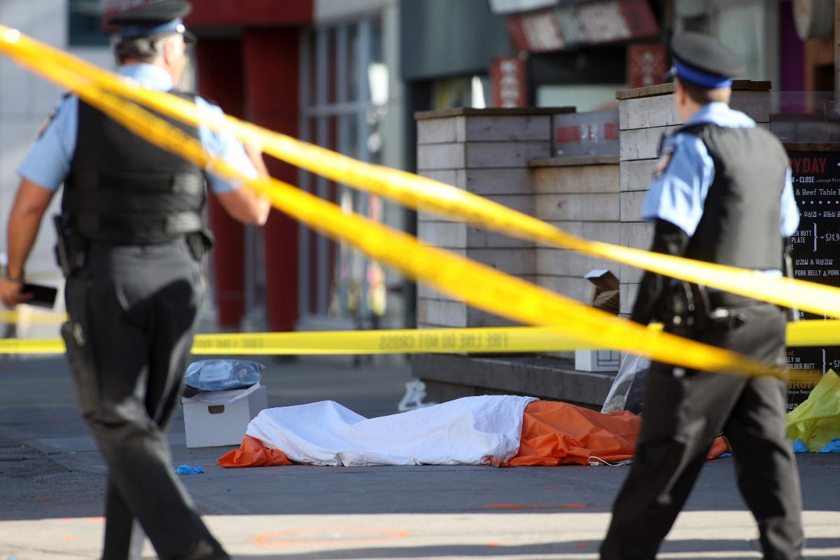 Policiais de Toronto isolam um corpo após o atropelamento na tarde desta segunda-feira (23) | LARS HAGBERG/AFP