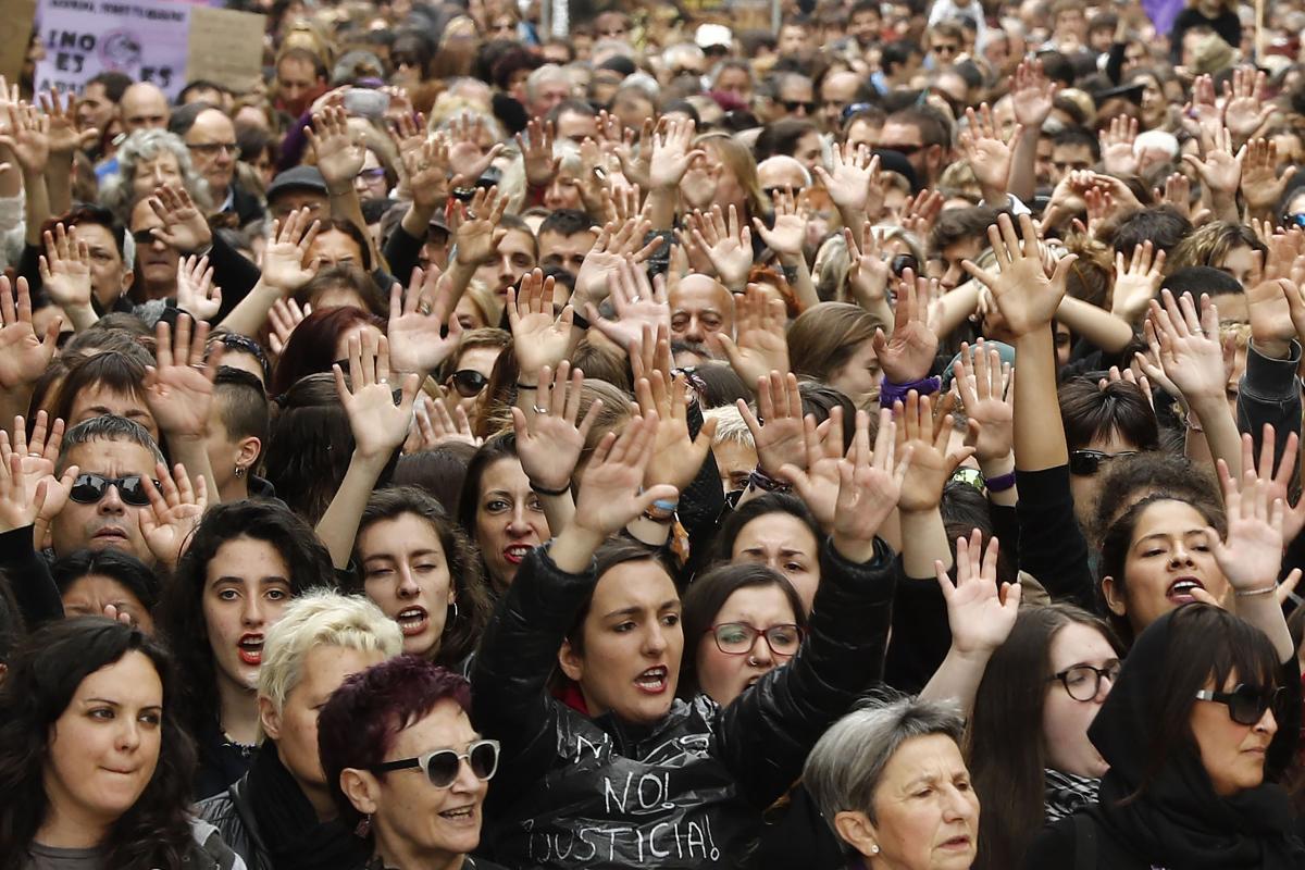 Várias pessoas levantam as mãos e gritam durante um protesto em Pamplona contra o abrandamento da pena aos cinco homens acusados de estupro coletivo | XABIER LERTXUNDI/AFP