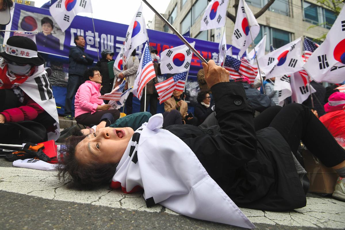 Partidária da ex-presidente da Coreia do Sul Park Geun-hye reage depois que um tribunal a condenou a 24 anos de prisão. A ex-presidente Park Geun-hye foi presa por corrupção, encerrando uma dramática queda para a primeira mulher líder do país | JUNG YEON-JE/AFP