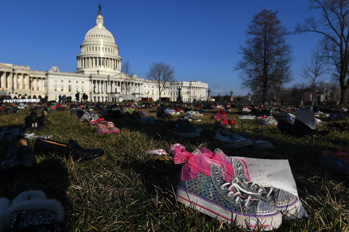 Calçados são colocados na grama em frente ao Capitólio dos EUA como um memorial para crianças mortas em massacres desde o episódio na escola Sandy Hook, em 2012 | Melina Mara/The Washington Post