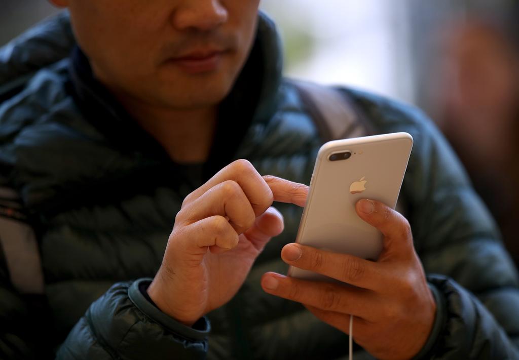 Homem usa um iPhone. | JUSTIN SULLIVAN/AFP