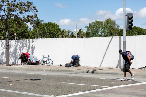 Um homem passa por pertences de pessoas desabrigadas em Santa Ana Blvd. Residentes em áreas de rápida gentrificação estão ficando cada vez mais frustrados com o nível de falta de moradia e inatividade por parte dos políticos | Philip Cheung/Washington Post