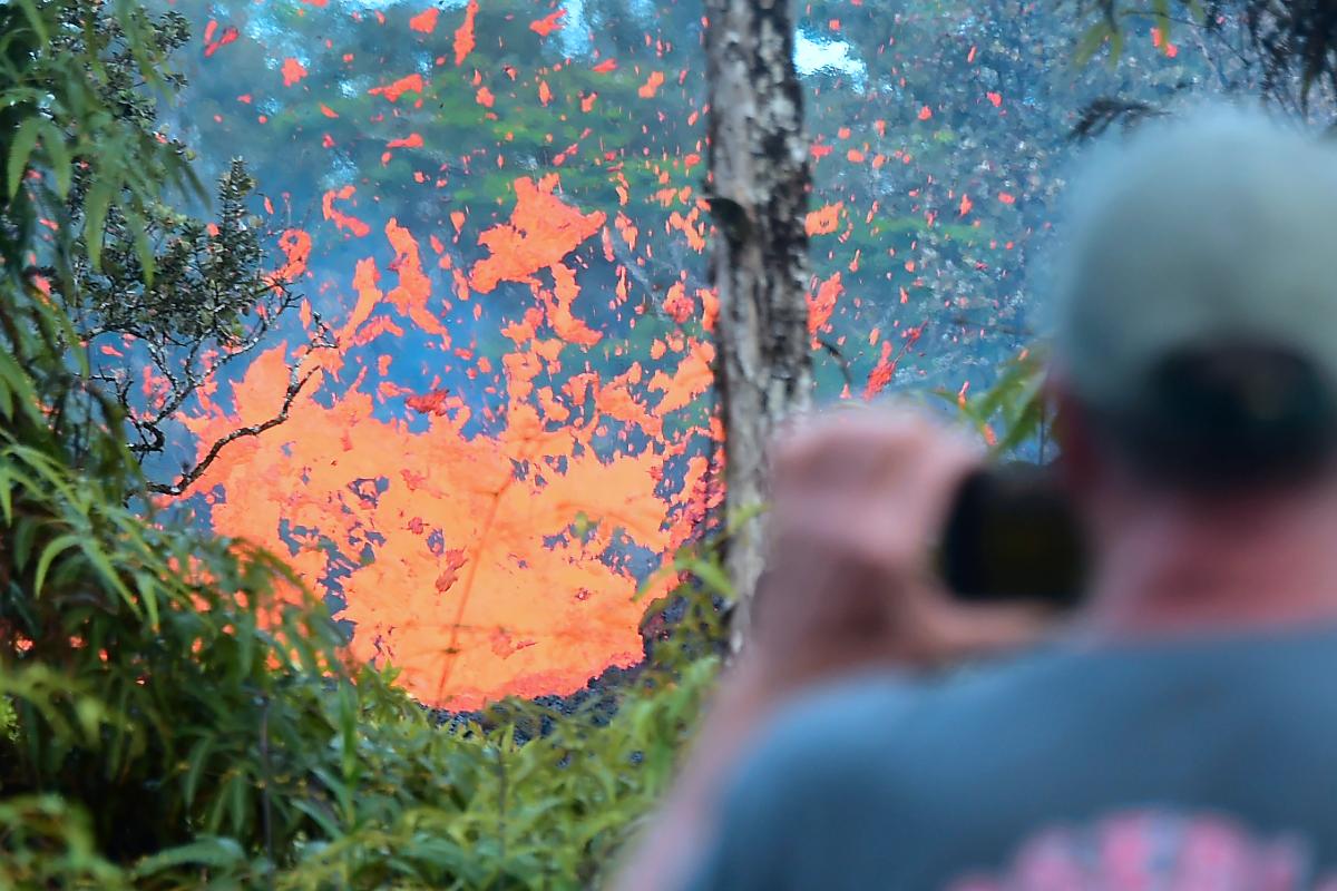 Homem observa a lava fluir de uma fissura perto da cidade de Pahoa, na Grande Ilha do Havaí, em 4 de maio de 2018, quando 10.000 pessoas deixaram suas casas após a erupção do vulcão Kilauea. | FREDERIC J. BROWN/AFP