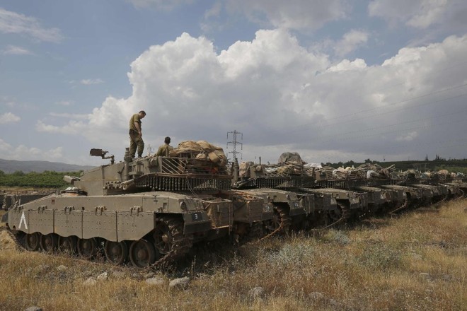 Tanques israelenses guardam posições próximo à fronteira com a Síria, nas colinas de Golã | JALAA MAREY/AFP