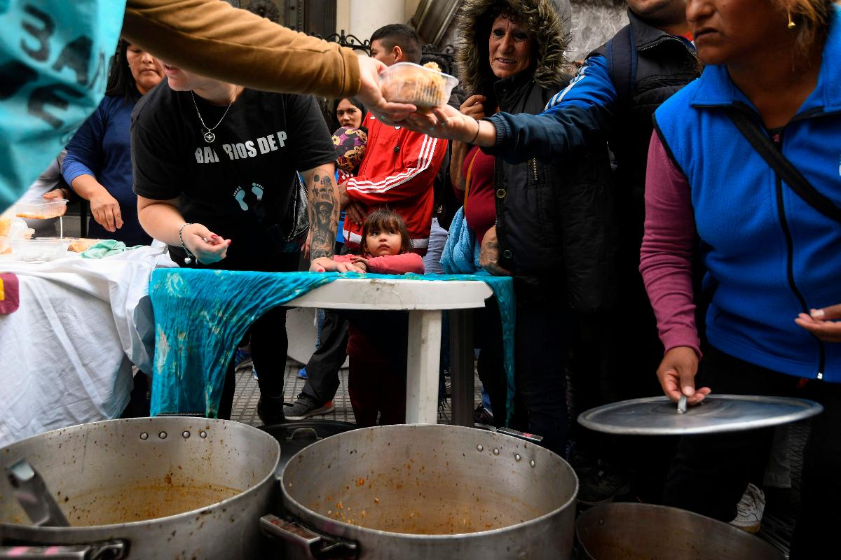 Pessoas recebem sopa, em frente ao Banco Central da Argentina, em Buenos Aires. Peso perdeu 25,5% de seu valor em um ano | EITAN ABRAMOVICH/AFP