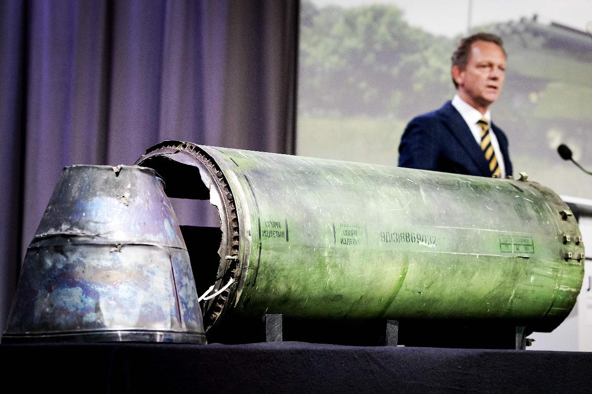Procurador-chefe Fred Westerbeke fala em nome dos investigadores em uma coletiva de imprensa; ao lado, parte do foguete BUK que foi disparado contra o voo MH17 da Malaysia Airlines | ROBIN VAN LONKHUIJSENAFP
