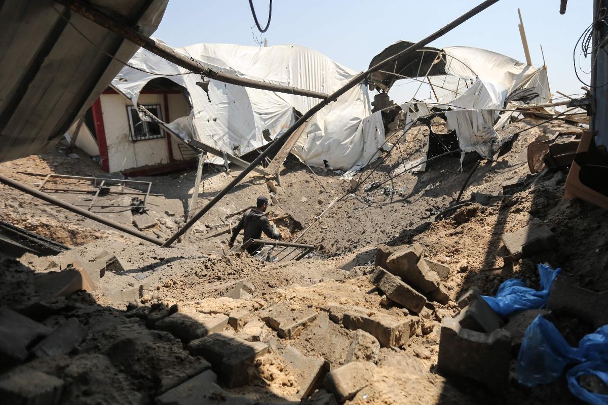 Homem inspeciona local atingido por ofensiva aérea israelense em Khan Younis, no Sul da Faixa de Gaza | MAHMUD HAMS/AFP