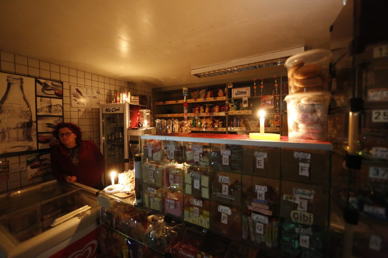 Velas acesas em banca de doces no terminal para garantir o atendimento. Foto: Lineu Filho/Tribuna do Paraná | Lineu Filho/Tribuna do Paraná