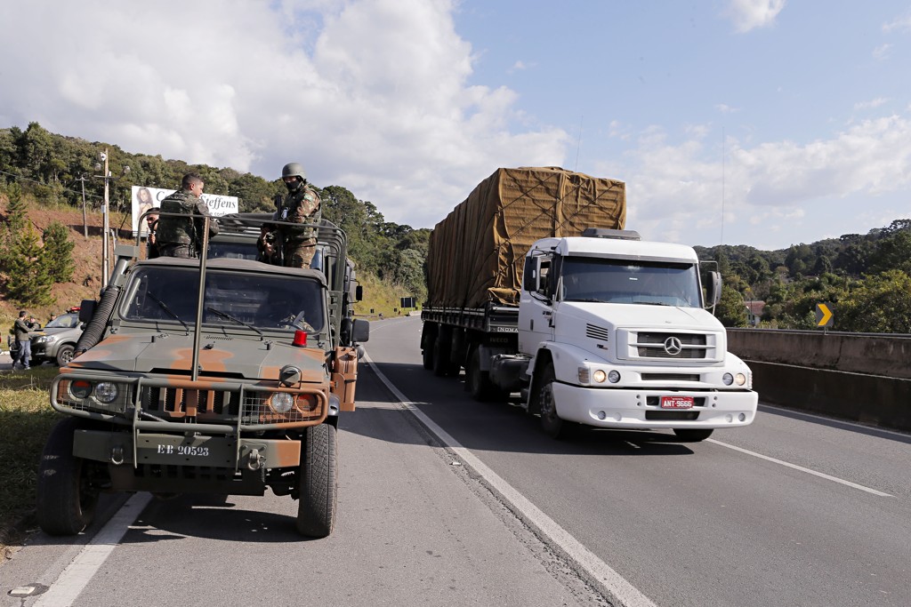 Caminhão passa ao lado de veículo do Exército: tropas têm ordem de dispersar qualquer aglomeração de caminheiros logo no início.
