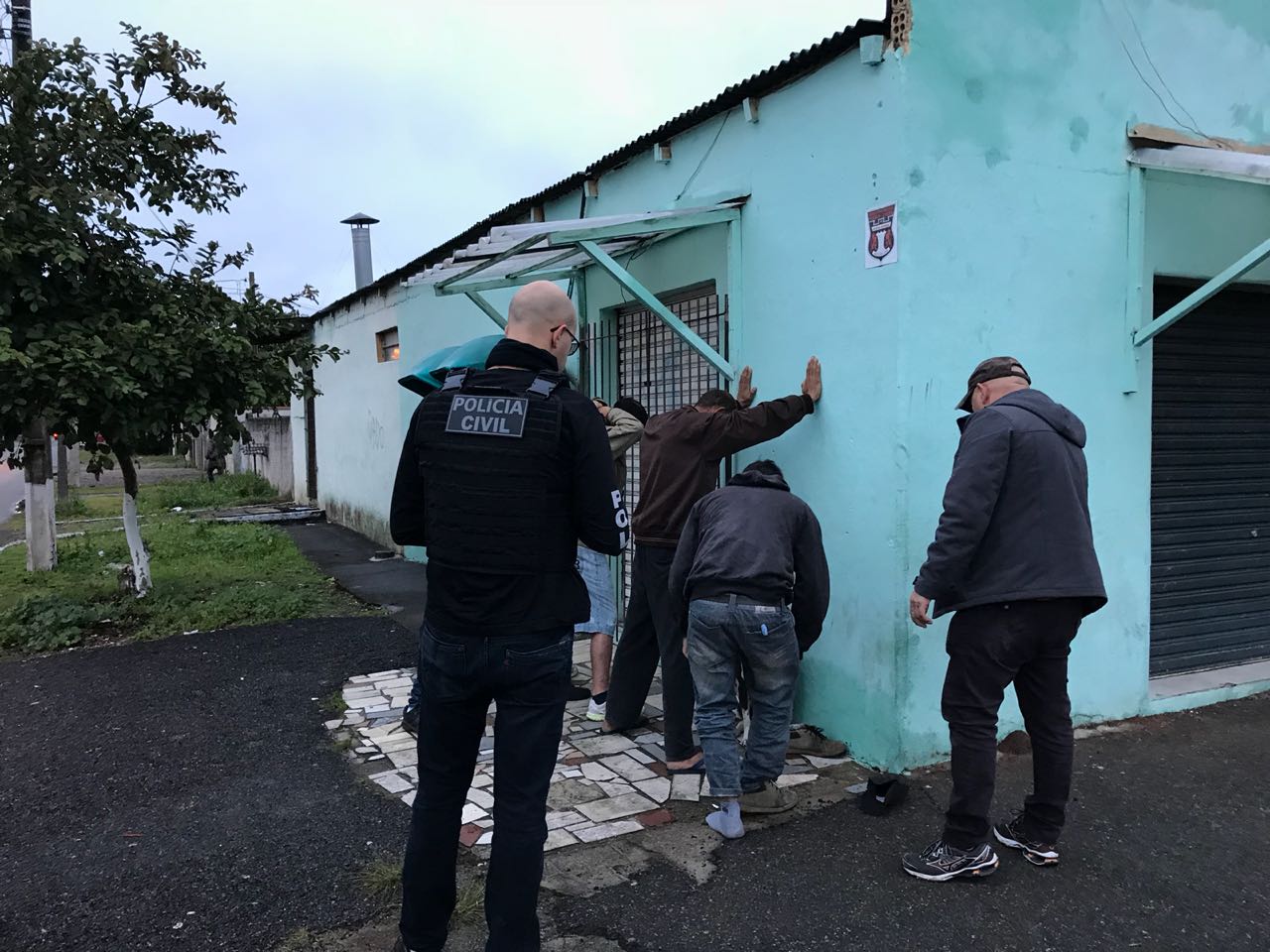 Policiais revistam suspeito nas proximidades de uma escola em Curitiba dentro da Operação Anjos da Lei. | Polícia Civil do Paraná/