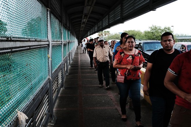 Pessoas cruzam a ponte que liga Brownsville, nos Estados Unidos, a Reynosa, no México | SPENCER PLATT/
AFP