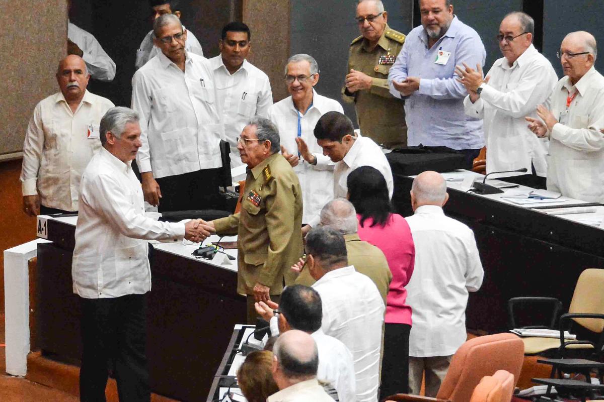 Presidente de Cuba, Miguel Diaz-Carnel (E), cumprimenta seu antecessor, Raul Castro (D), durante sessão extraordiária do Parlamento | STR/AFP
