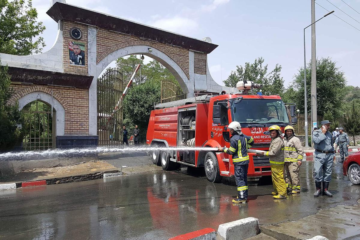 Bombeiro afegão em frente aos portões da Universidade Politécnica de Cabul, em Cabul, onde ocorreu um ataque terrorista suicida nesta segunda-feira (4) | AHMAD ZAFARAFP