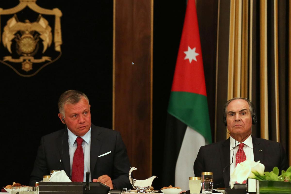 O rei da Jordânia Abdullah II (D) e o ex-primeiro-ministro Hani Mulki (E) em uma reunião no Palácio Real em Amã, em maio de 2018 | KHALIL MAZRAAWIAFP