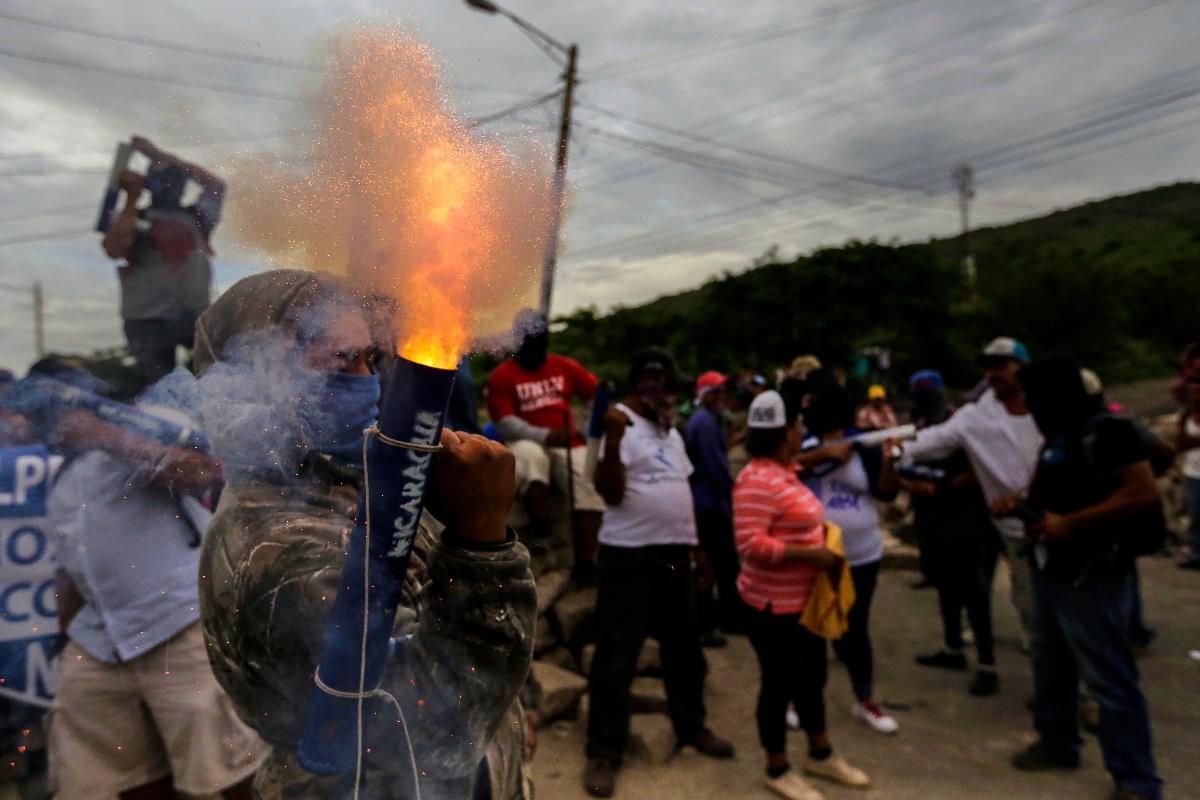 Um manifestante acende um morteiro durante confrontos com a polícia na cidade Las Maderas, na Nicarágua, nesta quarta-feira (6) | INTI OCONAFP