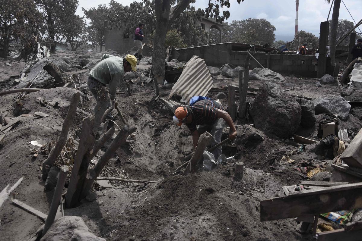 Moradores de San Miguel Los Lotes, na Guatemala, procuram por sobreviventes da erupção do Vulcão do Fogo | JOHAN ORDONEZ/AFP