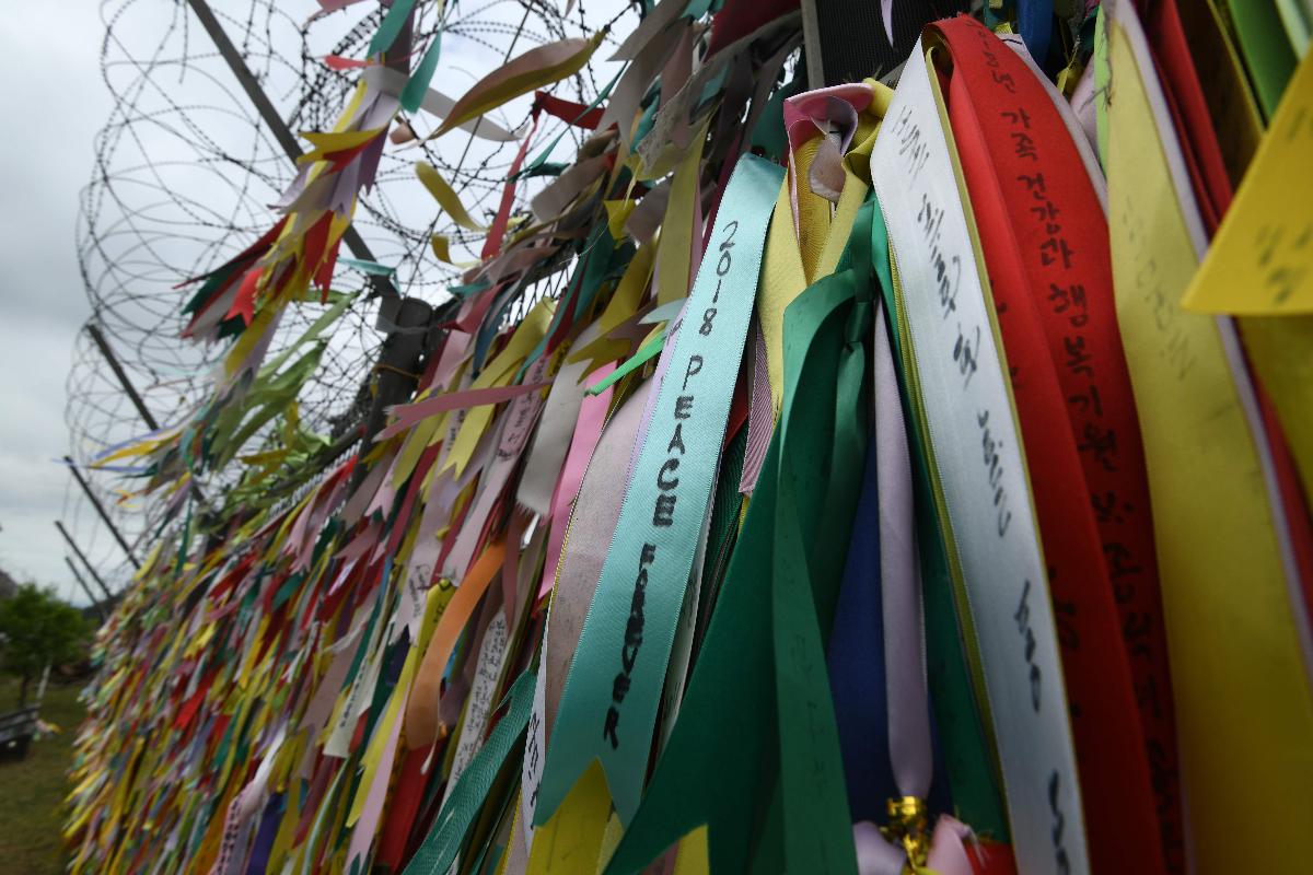 Fitas pedindo pela paz e reunificação das Coreias foram amarradas em cerca militar perto da zona desmilitarizada, na Coreia do Sul  | JUNG YEON-JE
AFP