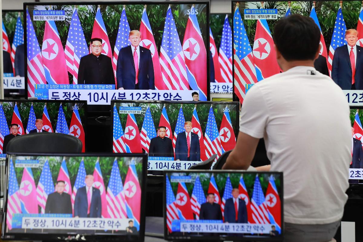 Um homem assiste a telas de televisão que noticiam a cúpula entre o presidente dos EUA, Donald Trump, e o líder norte-coreano Kim Jong-un, em uma loja de eletrônicos em Seul | -AFP