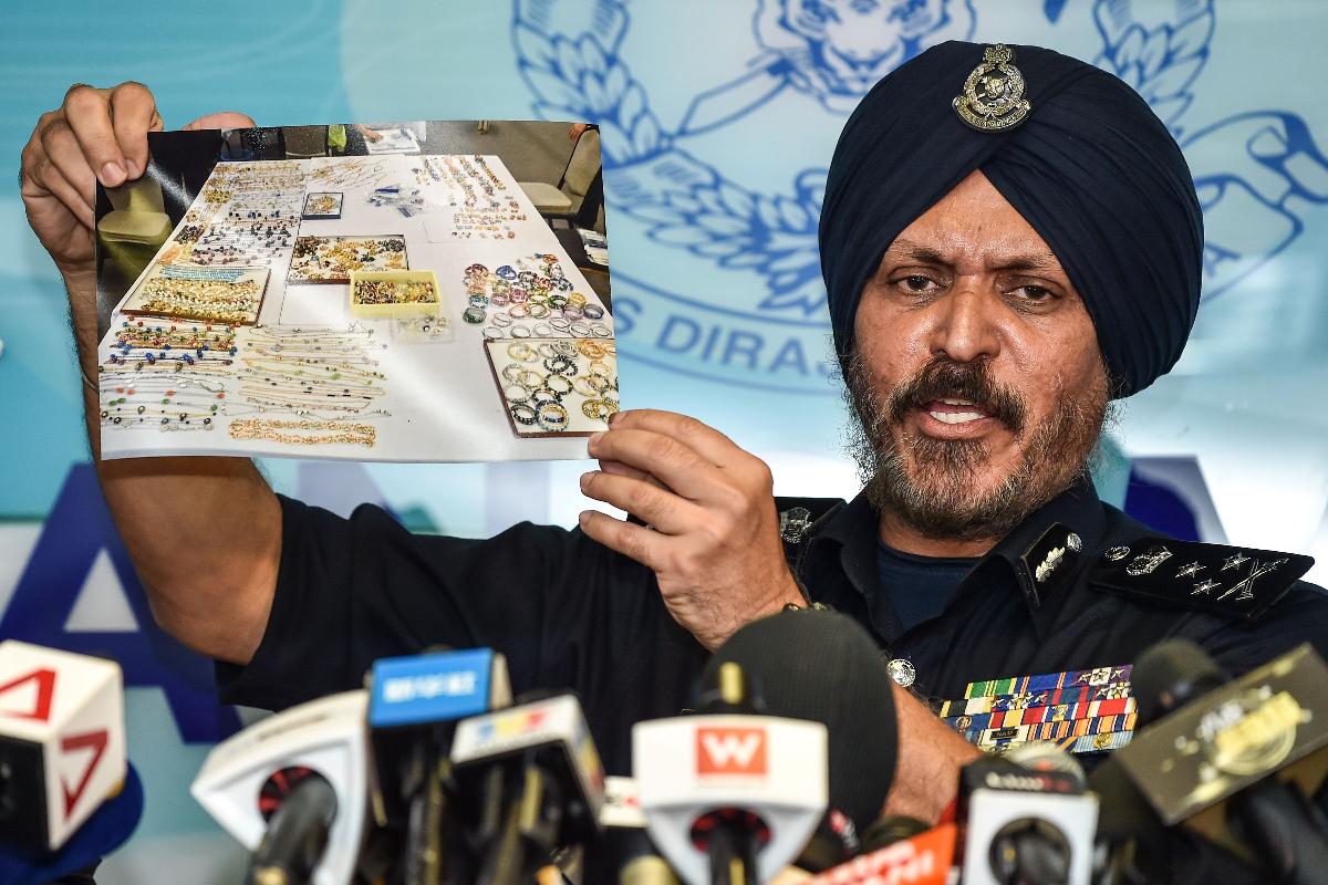 Amar Singh, chefe do Departamento de Investigação de Crimes Comerciais da polícia da Malásia, mostra aos repórteres as imagens doas joias apreendidas | MOHD RASFANAFP