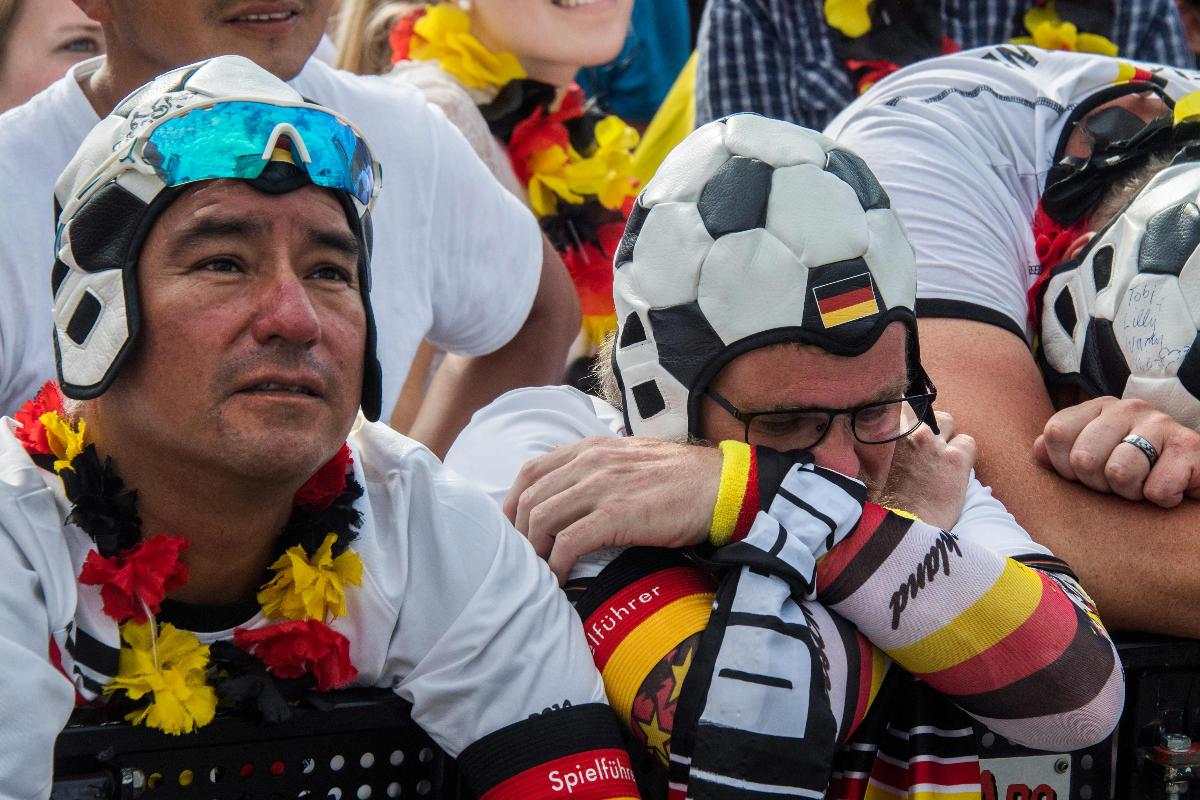 Torcedores alemães lamentam a derrota da sua seleção para a Coreia do Sul, o que acabou resultando na eliminação da Copa | JOHN MACDOUGALL/AFP