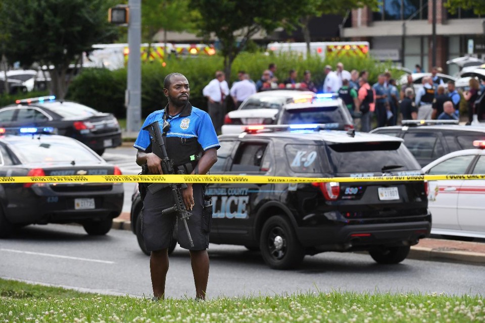 Policial vigia as redondezas do prédio onde aconteceu o tiroteio em Annapolis, no Nordeste dos Estados Unidos | Matt McClain/The Washington Post