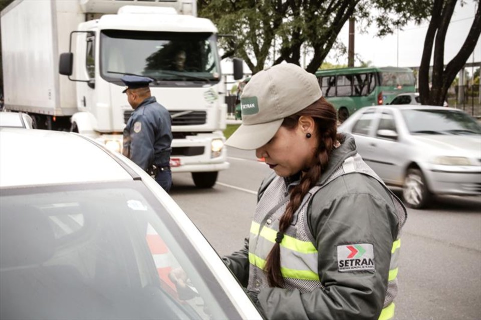 Agente de trânsito averigua documentação de carro: operação conjunta com a Polícia Militar. | Luiz Costa/Prefeitura de Curitiba