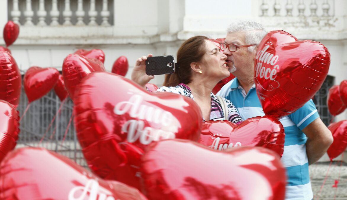 Casal comemora o Dia dos Namorados com os balões de coração na Praça Santos Andrade. | Aniele Nscimento/Gazeta do Povo