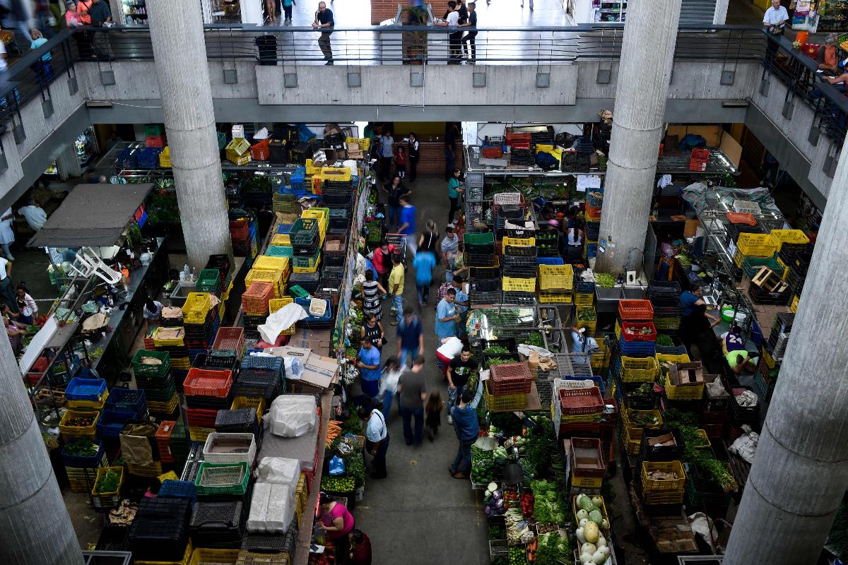 Pessoas fazem compras no mercado municipal de Chacao, em Caracas, em junho de 2018. A pior crise econômica da história da Venezuela causa falta de alimentos, água e medicamentos | FEDERICO PARRAAFP