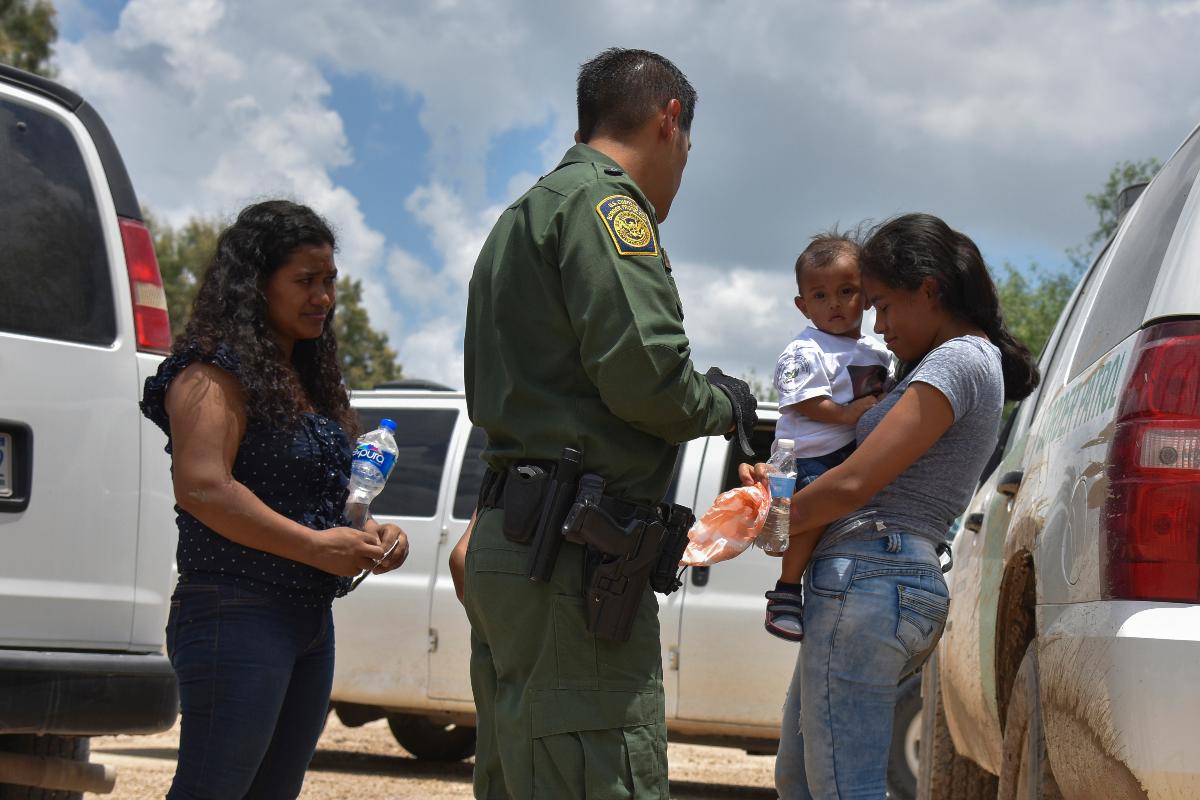 Duas mães de Honduras e seus filhos - uma de 12 anos, que não aparece na imagem, e uma de 1 ano - são detidas por um agente da Patrulha de Fronteira no Texas depois de atravessar o rio Grande | Jahi ChikwendiuThe Washington Post