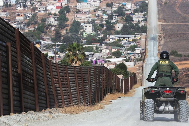 Agente da Patrulha da Fronteira americana monitora a cerca que separa os Estados Unidos do México. em San Diego | MARIO TAMA/AFP