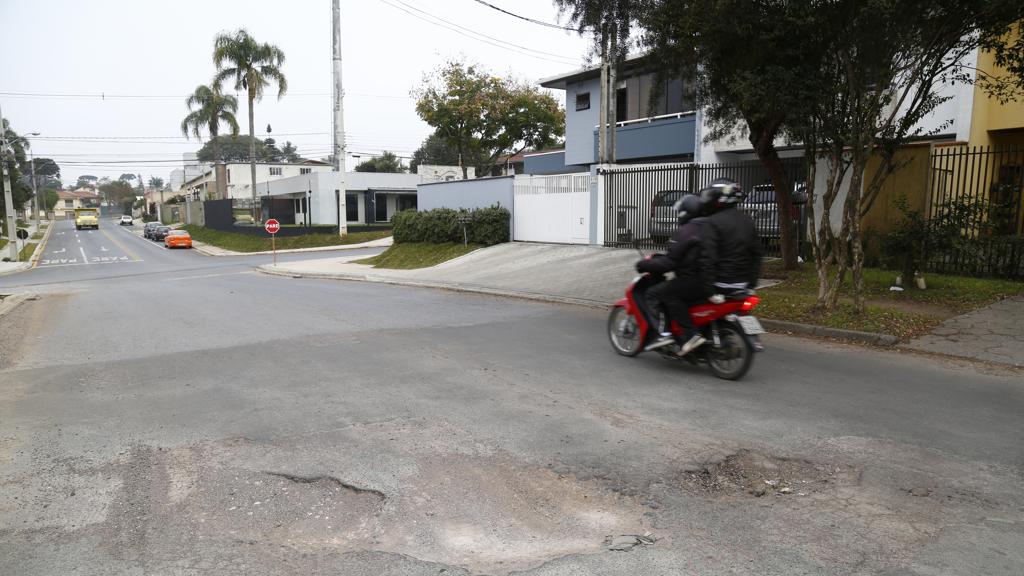 Contraste: ao fundo, a parte da Rua Deputado Antônio Lopes Junior que já foi revitalizada e a parte esburacada que aguarda asfalto novo. | Aniele Nascimento/Gazeta do Povo