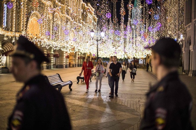 Forças policiais russas montam guarda enquanto torcedores e turistas comemoram na Praça Vermelha de Moscou | ODD ANDERSENAFP