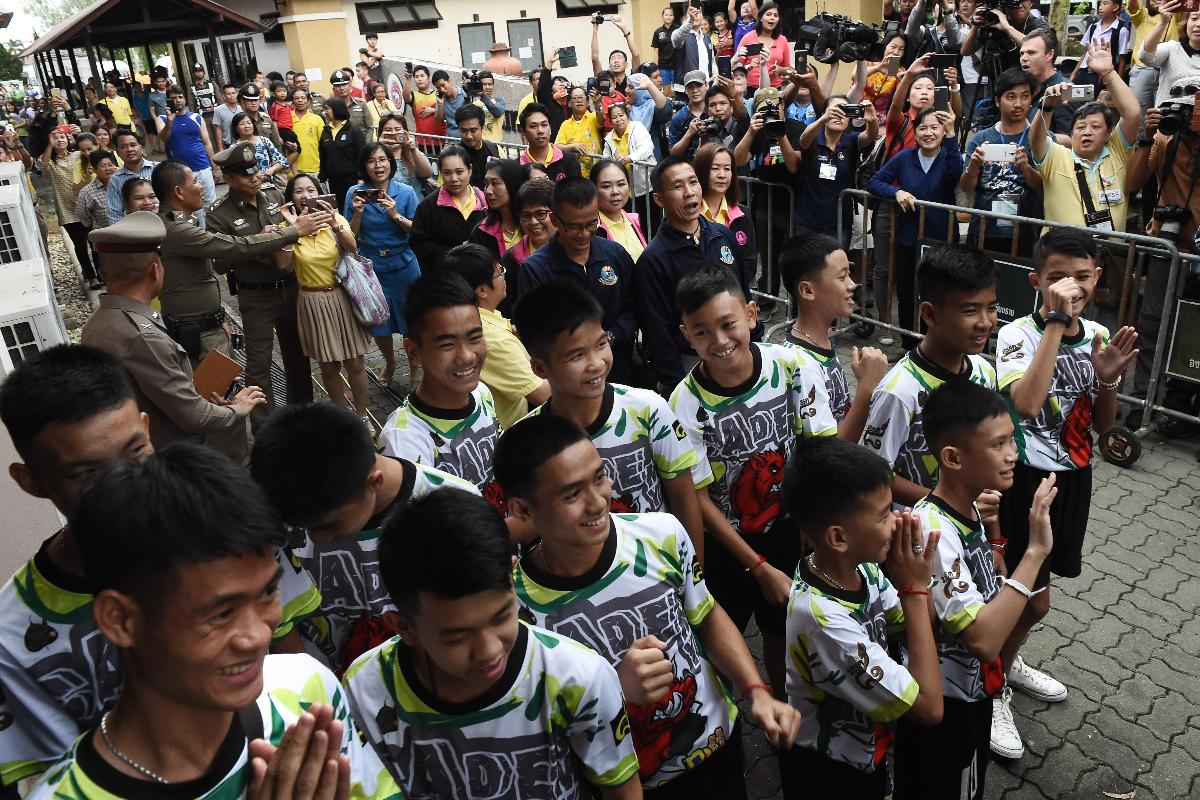 Vestindo a camiseta de seu time, os Javalis Selvagens, os 12 meninos e seu treinador conversaram com jornalistas depois de serem liberados do hospital | LILLIAN SUWANRUMPHAAFP