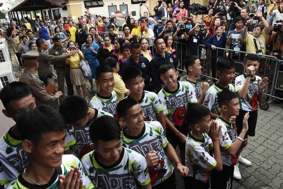 Vestindo a camiseta de seu time, os Javalis Selvagens, os 12 meninos e seu treinador conversaram com jornalistas depois de serem liberados do hospital | LILLIAN SUWANRUMPHAAFP