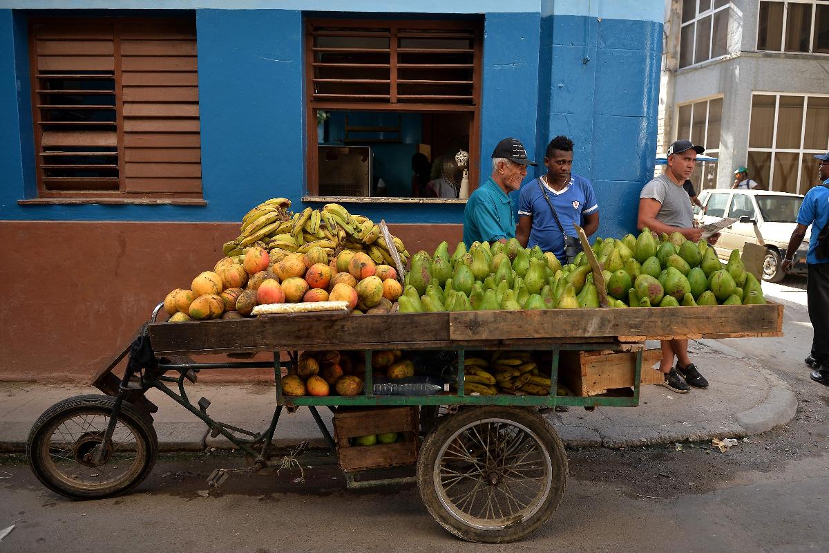 Comerciante vende frutas e outros vegetais em uma rua de Havana, a capital cubana | YAMIL LAGE/AFP