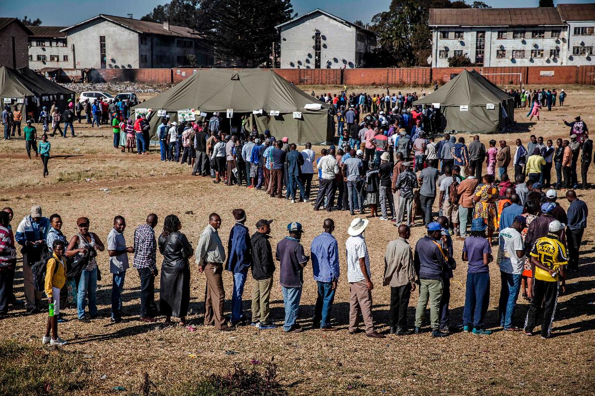 Pessoas fazem fila para votar em uma zona eleitoral no subúrbio de Mbare, na capital do Zimbábue, Harare, em 30 de julho | LUIS TATO/AFP
