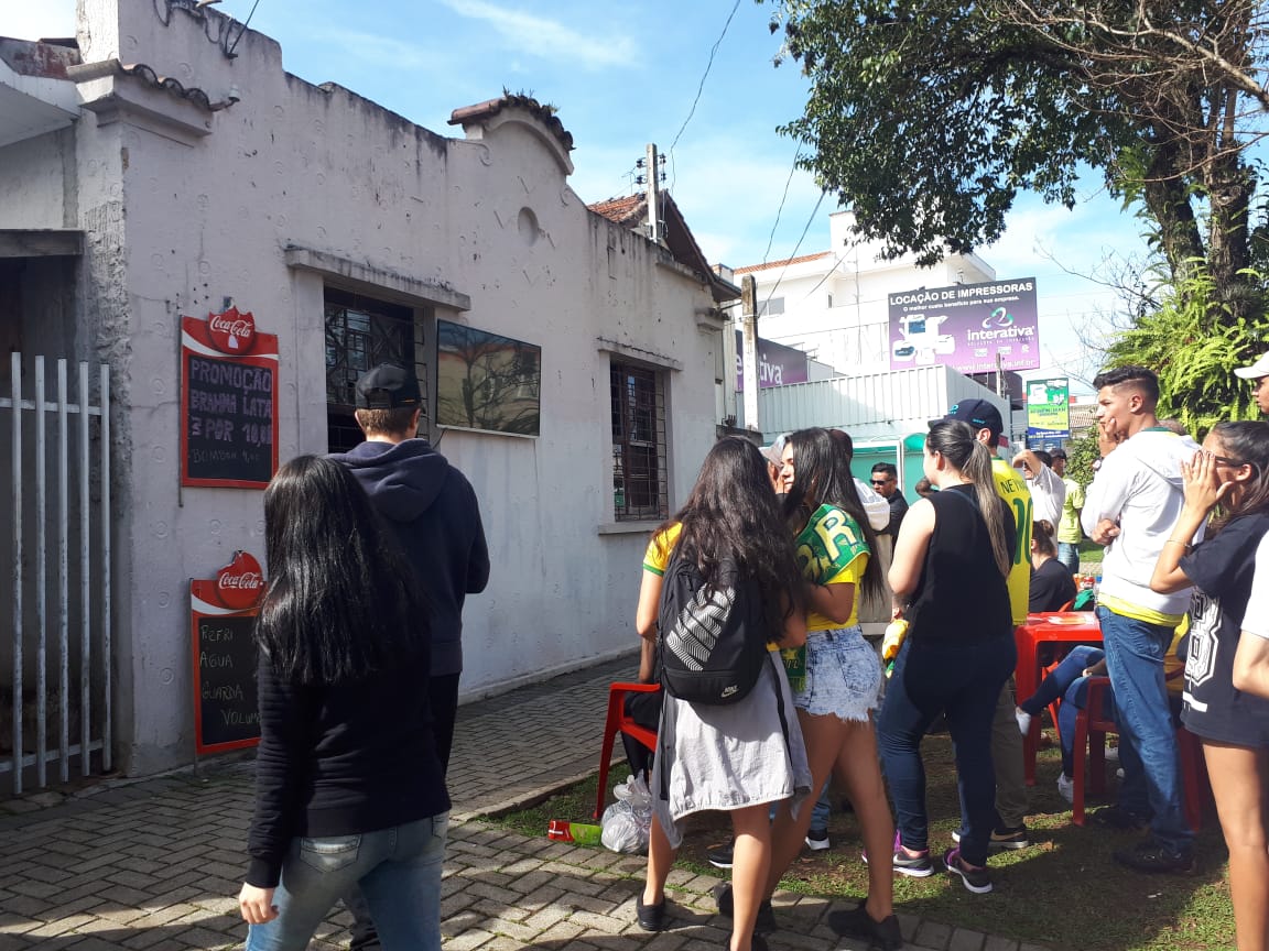 Torcedores que não conseguiram entrar na Arena da Baixada aproveitaram a TV na frente do bar para ver a vitória do Brasil sobre o México. | Raquel Derevecki/Gazeta do Povo