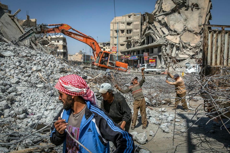 Homens procuram metal nos destroços do que foi um centro comercial, em Raqqa | IVOR PRICKETT/NYT