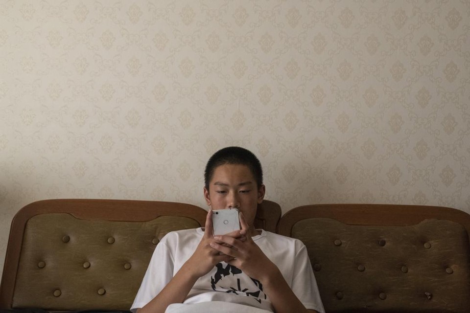 Na China, uma geração inteira está crescendo sem Google, Facebook ou Twitter Jovem chinês mexe em seu celular, que não tem acesso aos meus apps a que os brasileiros estão acostumados. | Gilles Sabriê/NYT