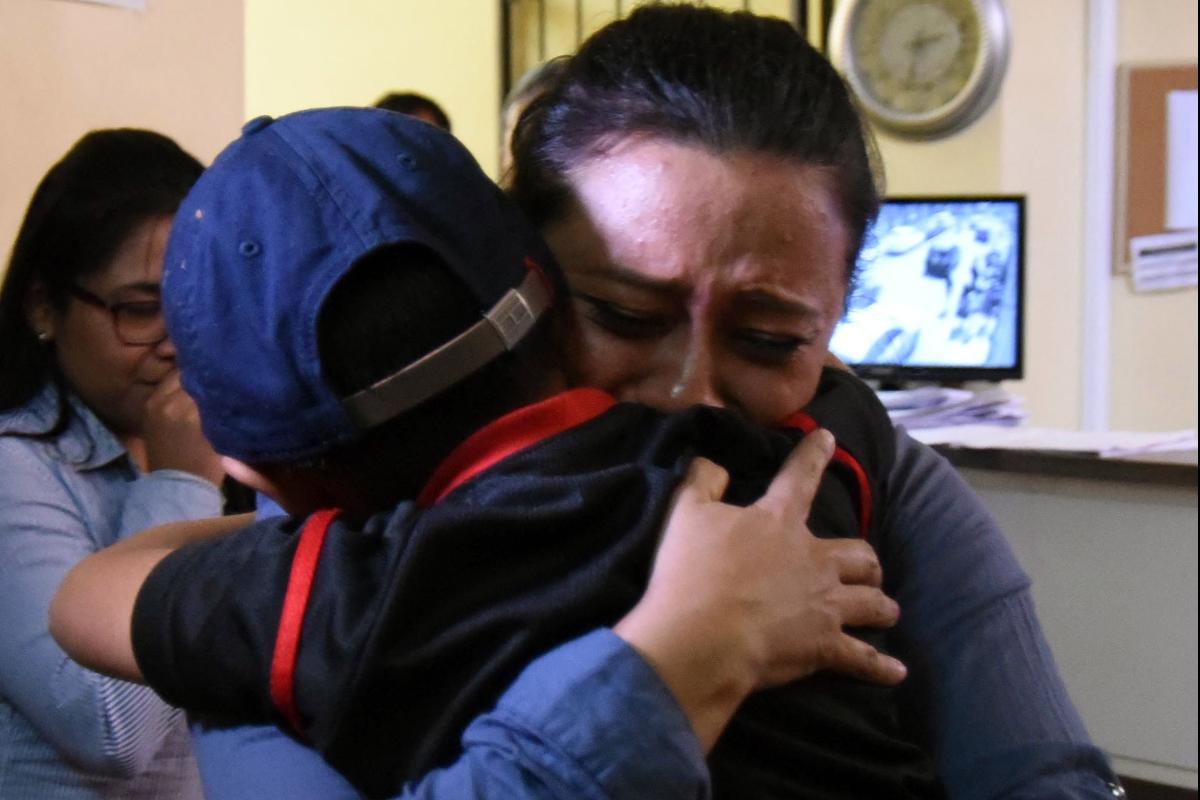Mãe abraça filho do qual  foi separado ao tentar cruzar a fronteira entre o México e os EUA | ORLANDO ESTRADAAFP