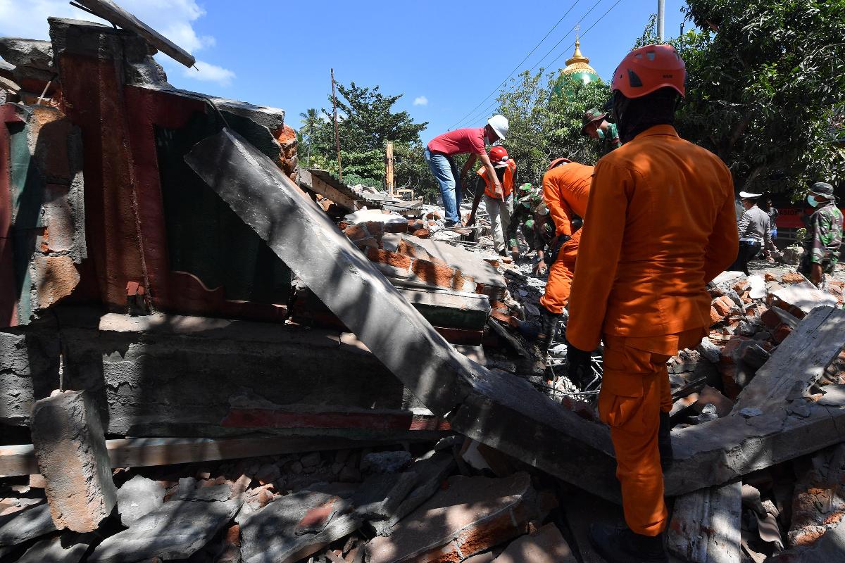 Membros de uma equipe de busca e resgate procuram vítimas do recente terremoto em Tanjung, na ilha de Lombok | ADEK BERRY/AFP
