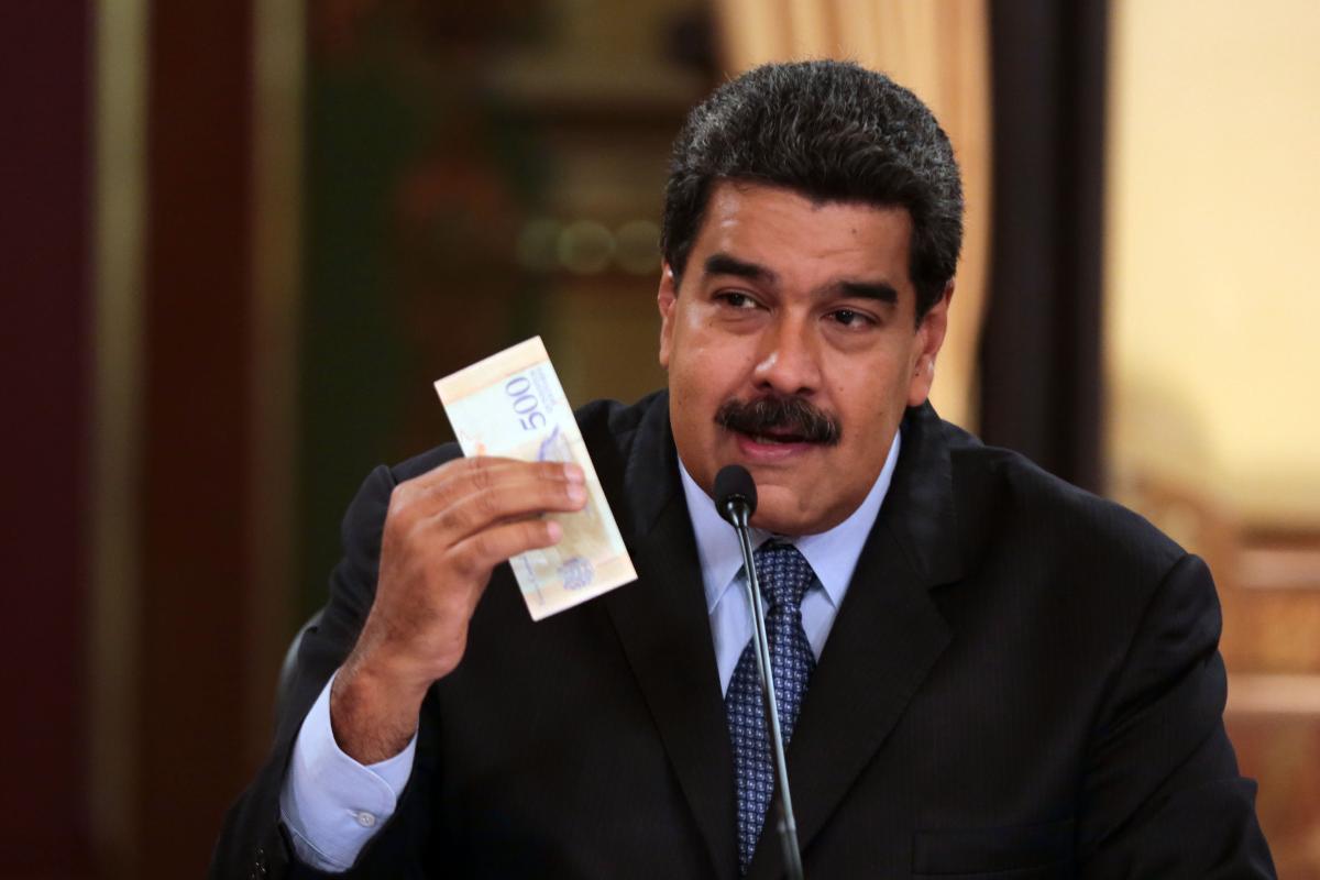 Ditador Nicolás Maduro, da Venezuela, segura nota de bolívar | AFP/Venezuelan Presidency