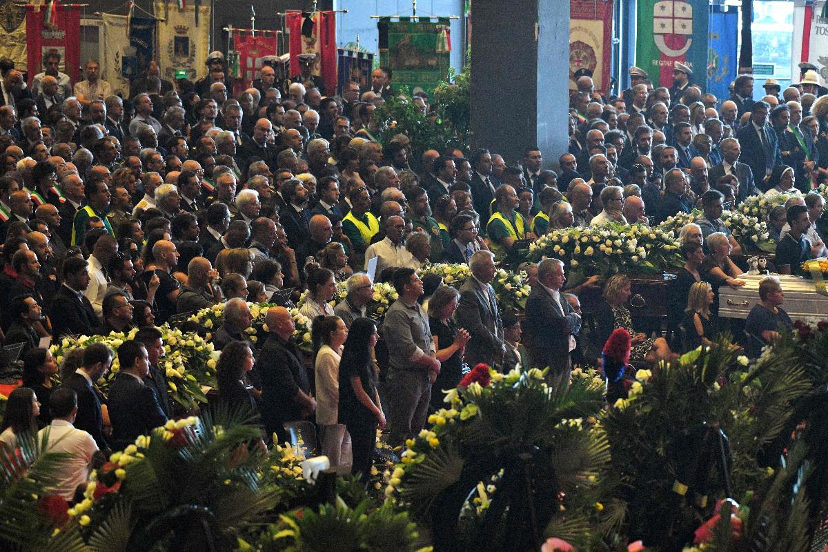 Familiares das vítimas e cidadãos da Itália durante o funeral das pessoas que morreram em consequência da queda da Ponte Morandi, em Gênova, na última terça-feira (14) | PIERO CRUCIATTI/AFP