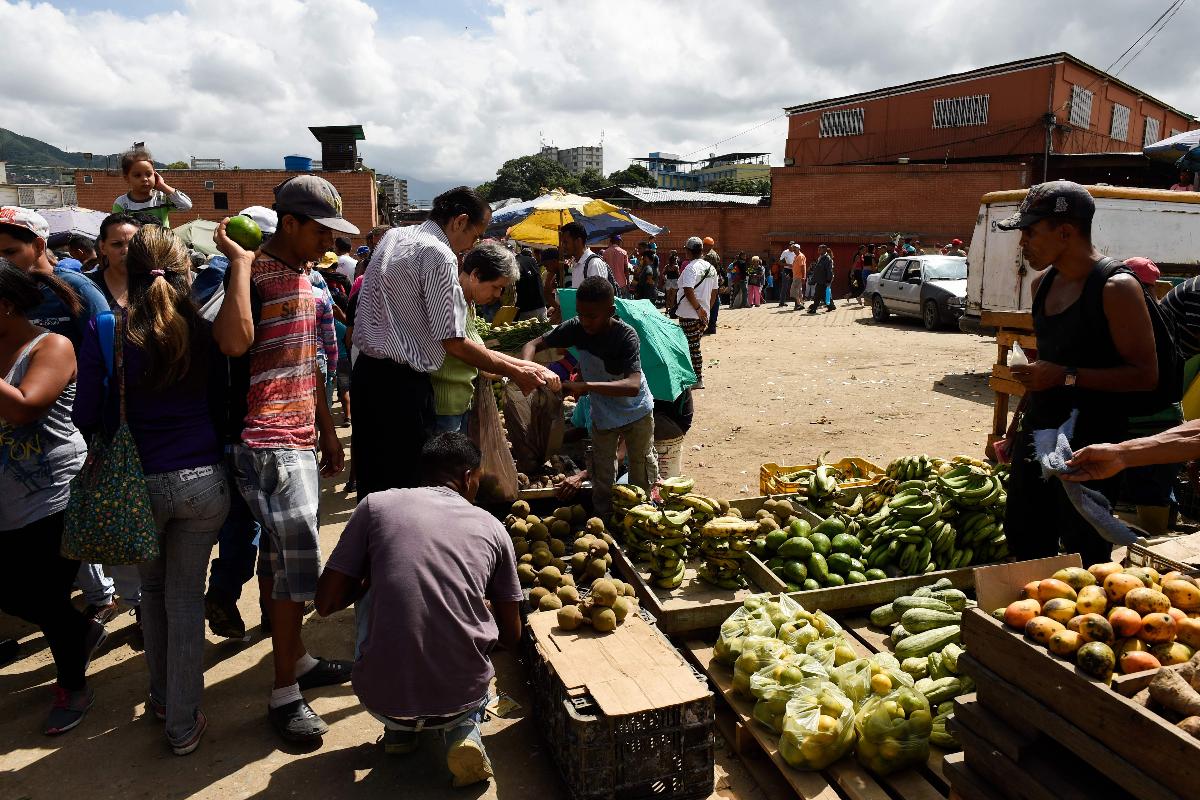 Pessoas compram mantimentos no mercado municipal de Coche, um bairro de Caracas, antes da emissão das novas notas de Bolivar | FEDERICO PARRA/AFP