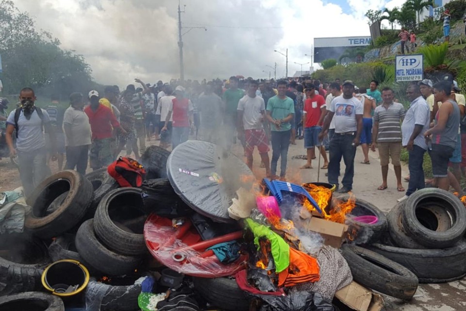Moradores da cidade de Pacaraima (RR) queimam pneus e pertences de imigrantes venezuelanos depois de atacar dois abrigos provisórios, em 18 de agosto | ISAC DANTES/ AFP