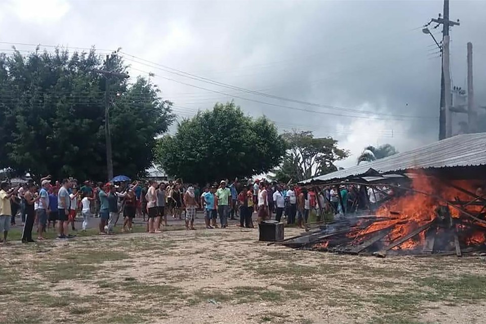 Moradores da cidade de Pacaraima, Roraima, queimam um abrigo para imigrantes venezuelanos, em 18 de agosto | ISAC DANTES/ AFP