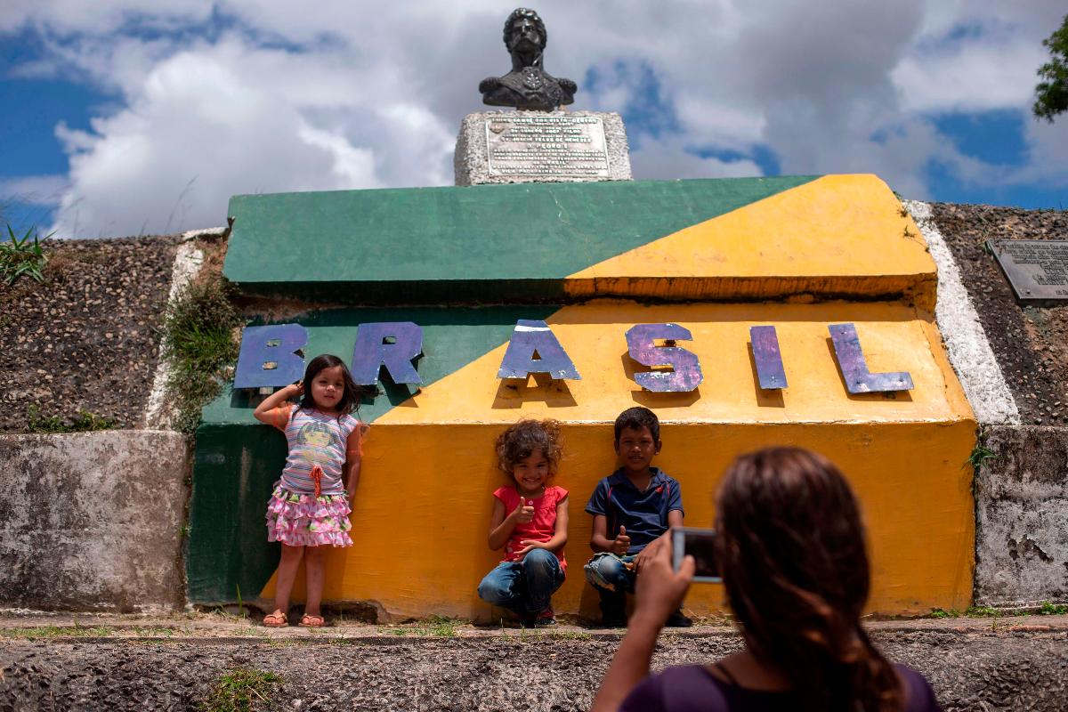 Crianças venezuelanas posam para foto na fronteira entre o Brasil e a Venezuela em Pacaraima, em Roraima | MAURO PIMENTEL/AFP