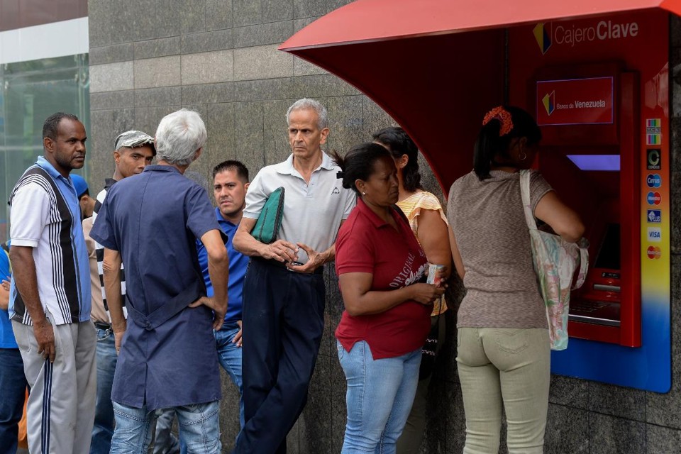 Pessoas fazem fila em caixa eletrônico em Caracas: saques chegaram a ser limitados a 10 bolívares, o equivalente a US$ 0,15 | FEDERICO PARRA/AFP