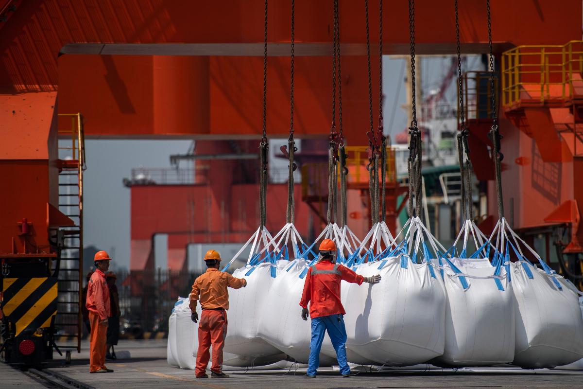 Carga de produtos químicos é desembarcada no porto chinês de Zhangjiagang | JOHANNES EISELE/AFP